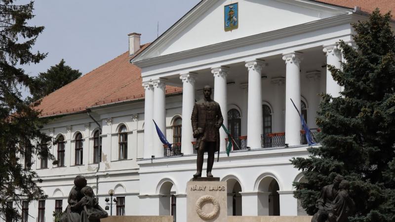 Makó tere, a múlt és a jelen találkozópontja, ahol négy különböző történelmi korszak szövi össze a maga egyedi szövetét. Itt a múlt emlékei és a jelen dinamizmusa találkozik, létrehozva egy különleges atmoszférát, amelyben a régmúlt titkai és a modern éle